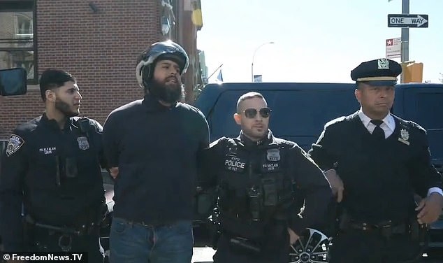 The man is then arrested by police officers while he is questioned by bystanders about how he managed to get past the barricades.