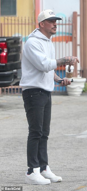 Jax kept it casual in a light gray hoodie and black jeans,