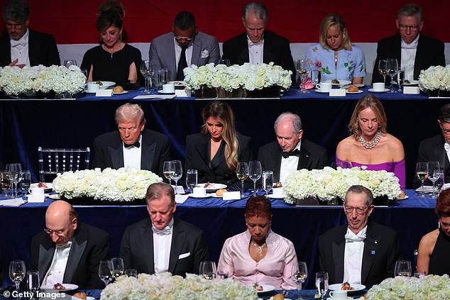 President Donald Trump and his wife Melania Trump bow their heads in prayer during the annual Alfred E. Smith Foundation Dinner at the New York Hilton Midtown on October 17, 2024