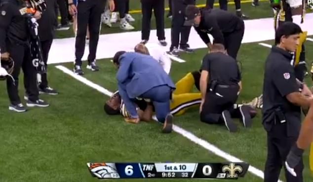 Adebo was left on the ground in pain after trying to tackle a Broncos running back