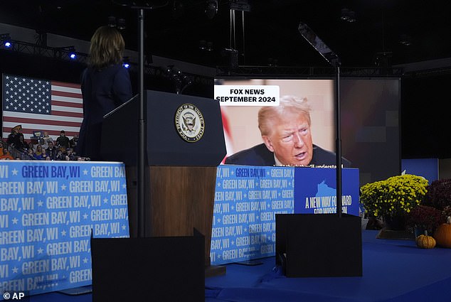 Harris watches a video with clips of Trump talking about abortion rights and overturning Roe during her rally in Green Bay. She has presented him in his own words at several events in recent days