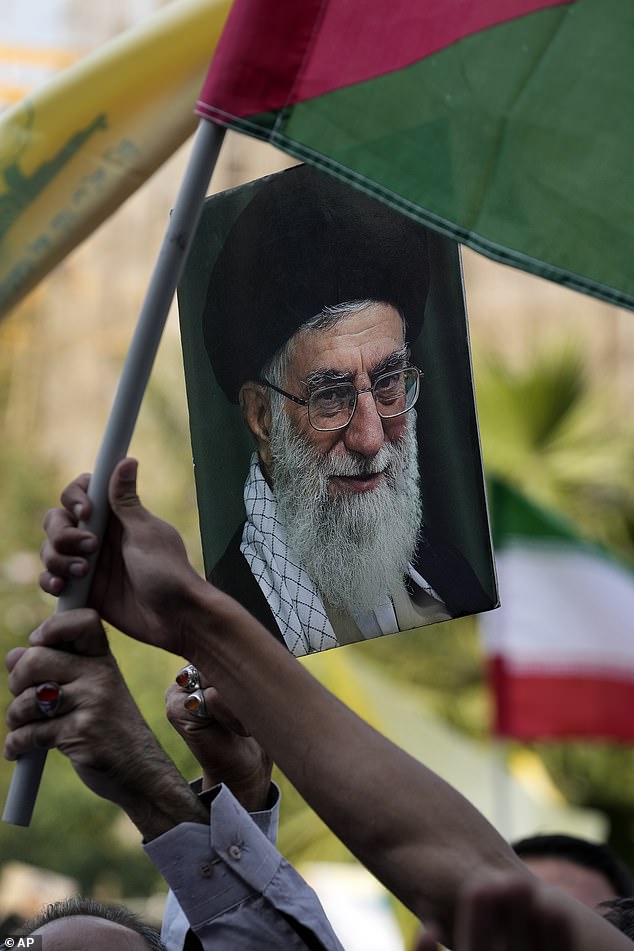 Iranian protesters wave a Palestinian flag and hold up a poster of Supreme Leader Ayatollah Ali Khamenei during an anti-Israel rally