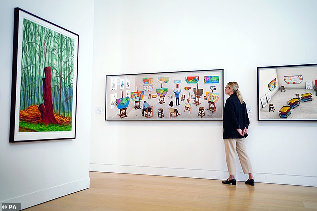 A woman looks at works of art by David Hockney, at Phillips in London, during the unveiling of the highlights of the David Hockney auction, September 14, 2023