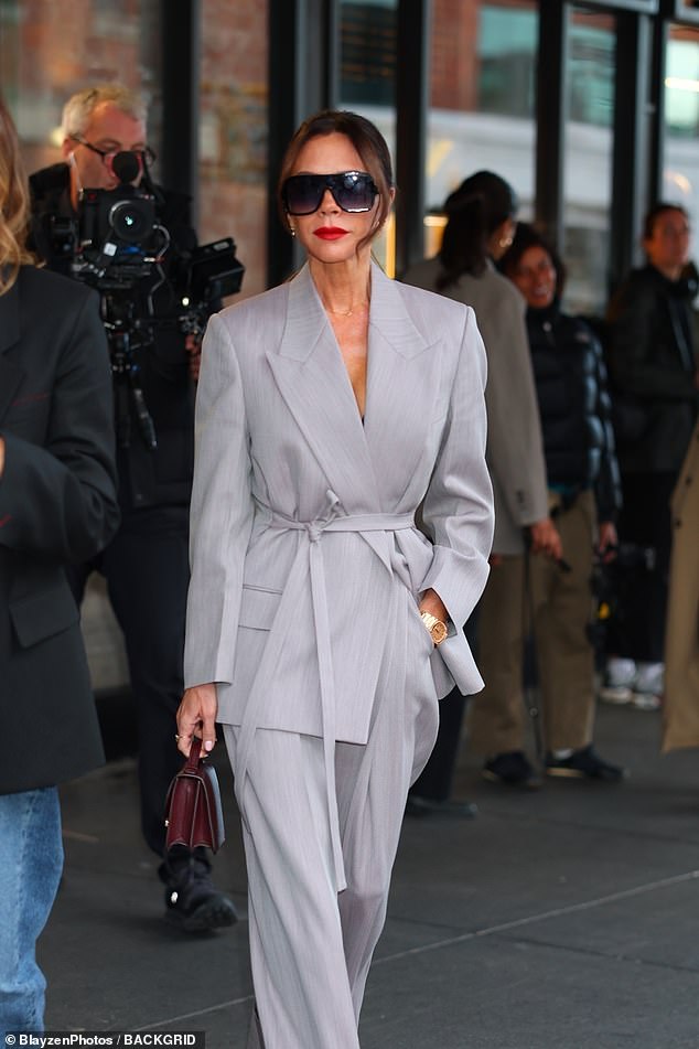 She shielded her eyes behind large sunglasses and wore minimal makeup with a classic red lip