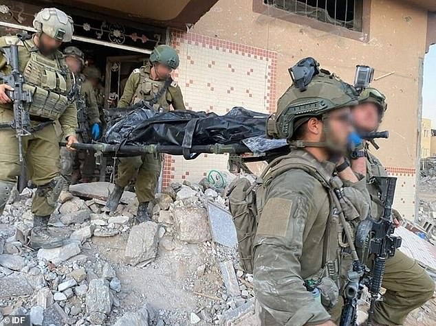 IDF soldiers carry Sinwar's body on a stretcher from the destroyed building