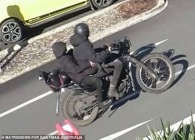 Pictured: Two people on a motorcycle, police say Phillips and his daughter, after allegedly robbing an ANZ bank