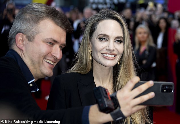 Angelina let her blonde locks fall loose over her shoulders and complimented her outfit with a pair of gold earrings