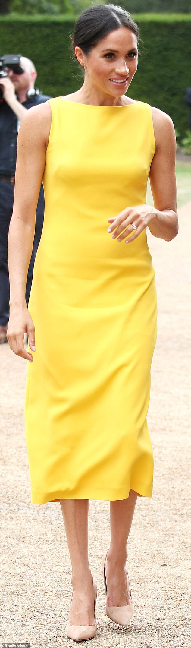 Meghan wears a simple Brandon Maxwell dress in a sunny color, closed Manolo shoes