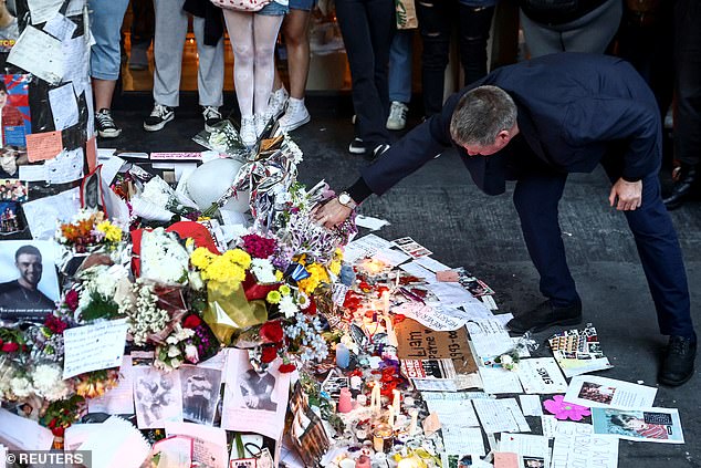 Geoff Payne (right) visits a memorial outside the Casa Sur Hotel where the British pop singer died