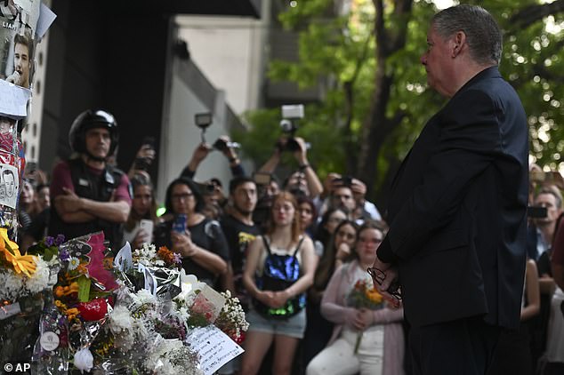 Crowds of fans watch as Geoff Payne reads tributes to his late son outside a hotel in Buenos Aires, Argentina