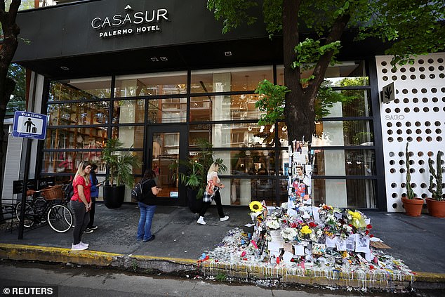 People stand next to tributes left outside the Casa Sur Hotel in Buenos Aires, where Liam was found dead on Thursday