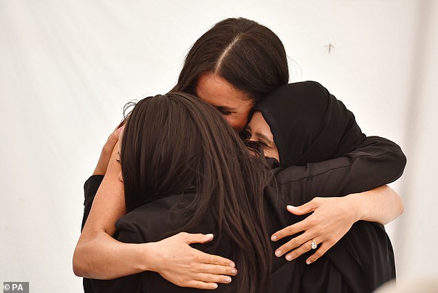 Meghan shared a hug with women she worked with at the Hubb Community Kitchen in 2018