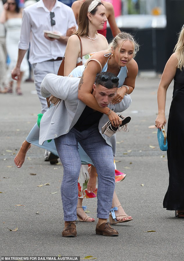 A young woman hitches a ride as she leaves Royal Randwick after the run of The Everest