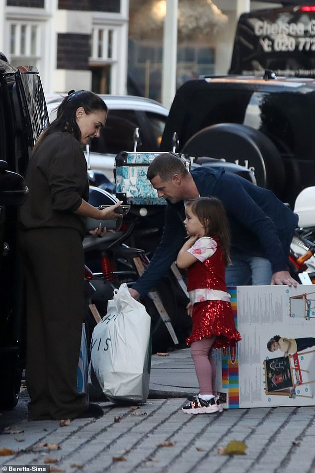 The heiress looked good-humored at the possible early Christmas shopping while interacting with the helpful gentleman and her young child