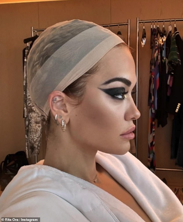 In BTS snaps, Rita sat in the makeup chair before the show