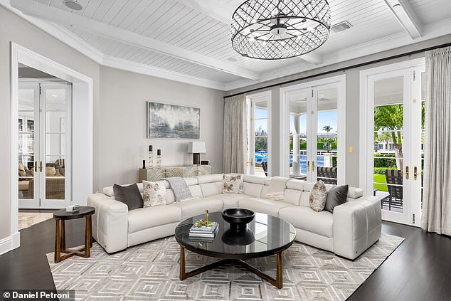 Soft seating and large windows bathe this living room space in natural light. It is an ideal place for relaxation or just for an informal conversation