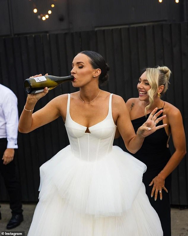 The happy bride drank champagne straight from the bottle and changed into much more comfortable clothes by removing the bottom layers of her wedding dress