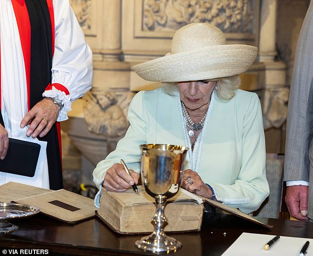 Queen Camilla signs a Bible and a book of communal prayer when she visits church