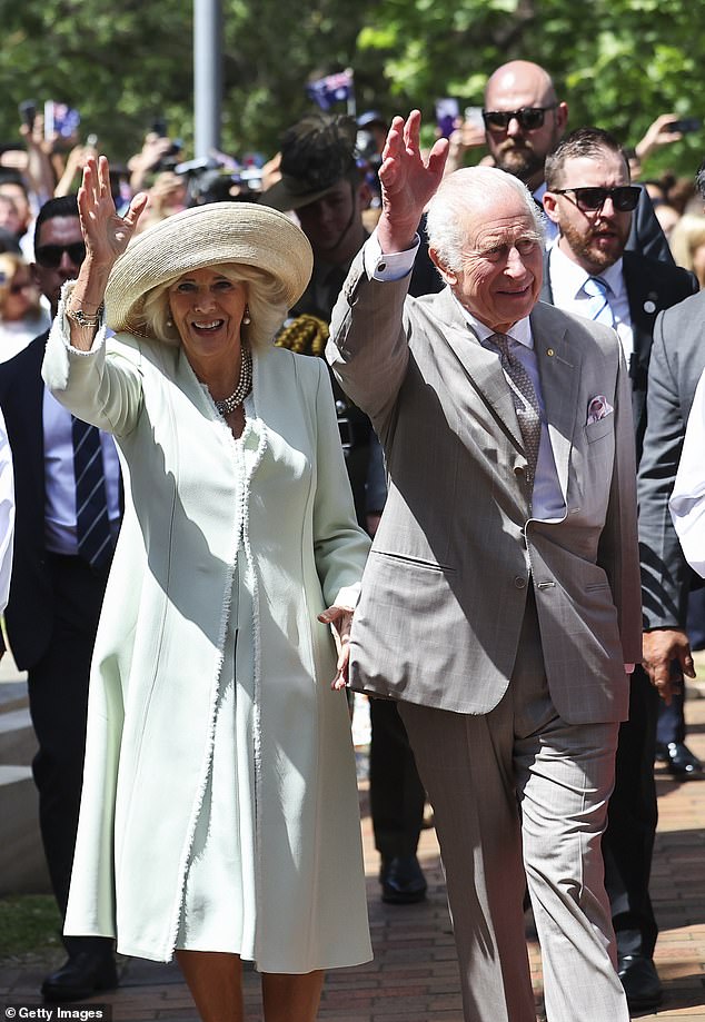 King Charles and Queen Camila wave to the crowds who have gathered to welcome their arrival in Sydney (pictured)