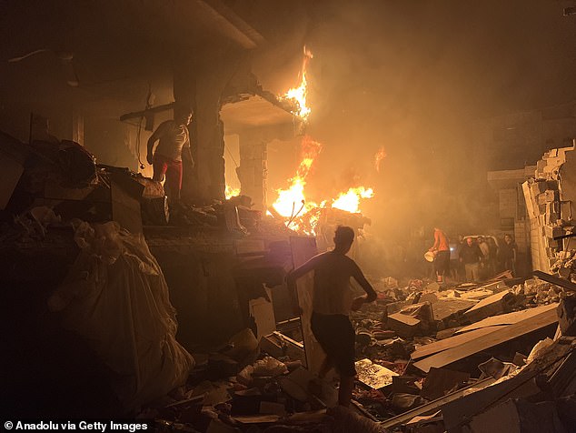 Civil defense teams and Palestinian residents extinguish the fire and search and rescue efforts at the Al-Salhi family home following Israeli attacks on the Nuseirat refugee camp in Gaza City, Gaza on October 15, 2024