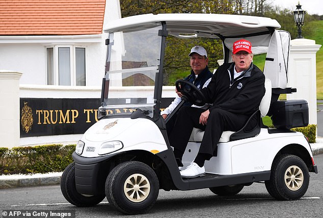 Trump drives a golf cart at the Trump Turnberry golf courses in Scotland in May 2023