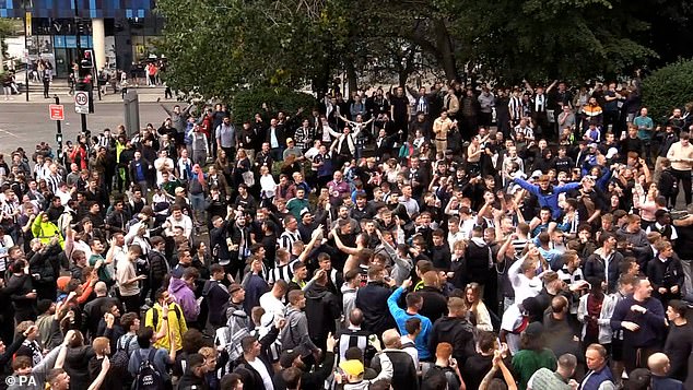 Cheering Newcastle United fans outside the stadium celebrate the Saudi takeover of the club