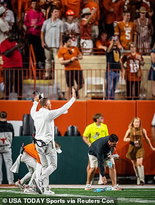 Longhorns coach Steve Sarkisian walks through the student section to encourage them to stop throwing objects on the field after a controversial call by the officials was overturned