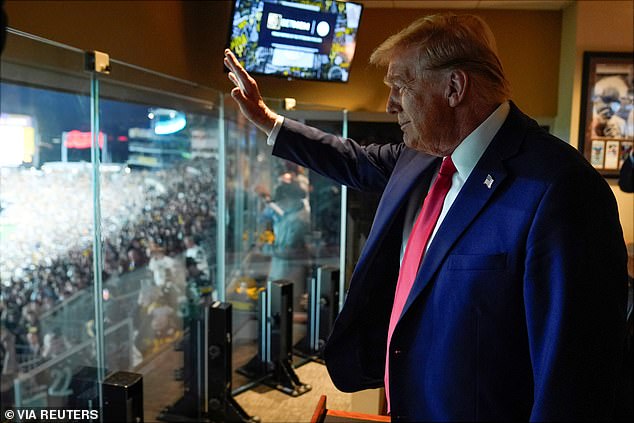 At one point, Trump could be seen waving to the crows from the comfort of his private suite