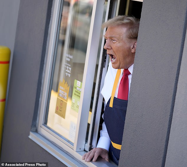 After handing out bags of takeout food to people in the drive-thru lane, Trump, still wearing the apron, leaned out the window to answer questions from the media stationed outside.