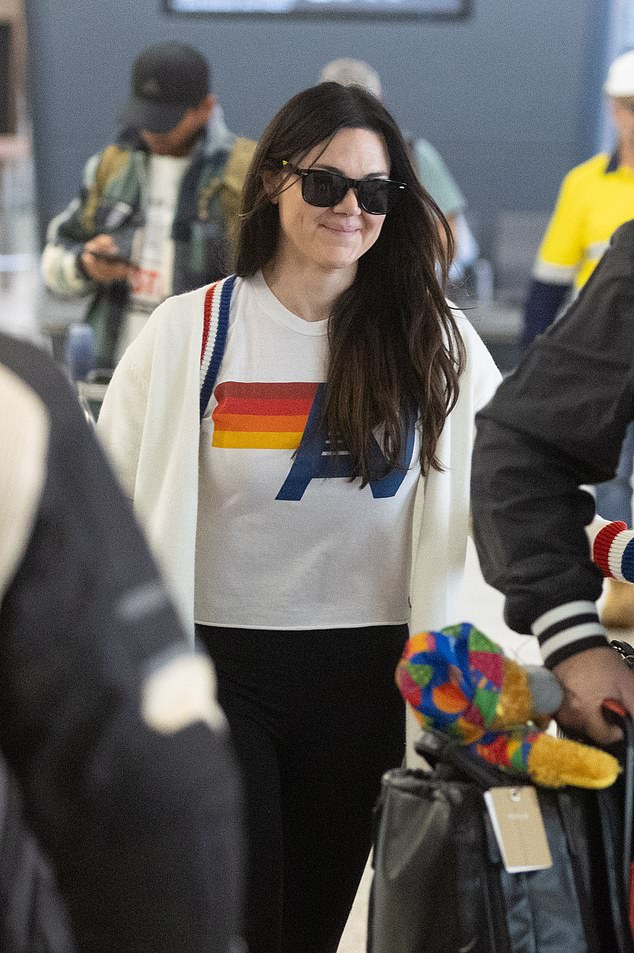 Later, a seemingly shy Vanessa donned black sunglasses and tried to hide behind a male friend as she left Melbourne's Tullamarine Airport.