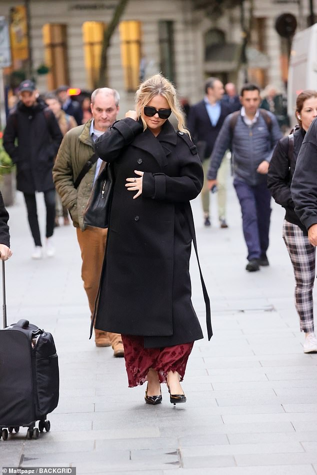 The actress bundled up against the chilly afternoon weather in the chic coat which she wore over a red patterned dress and black patent leather slingback heels.