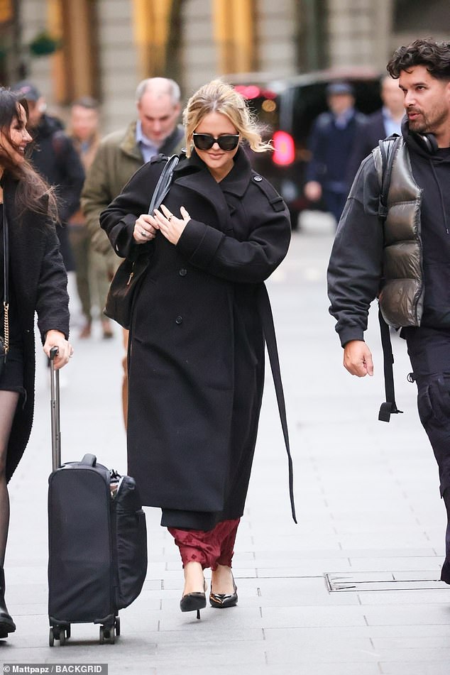 She finished her look with a large black bag and swept her hair into a loose bun, looking worlds away from her raunchy Rivals persona.