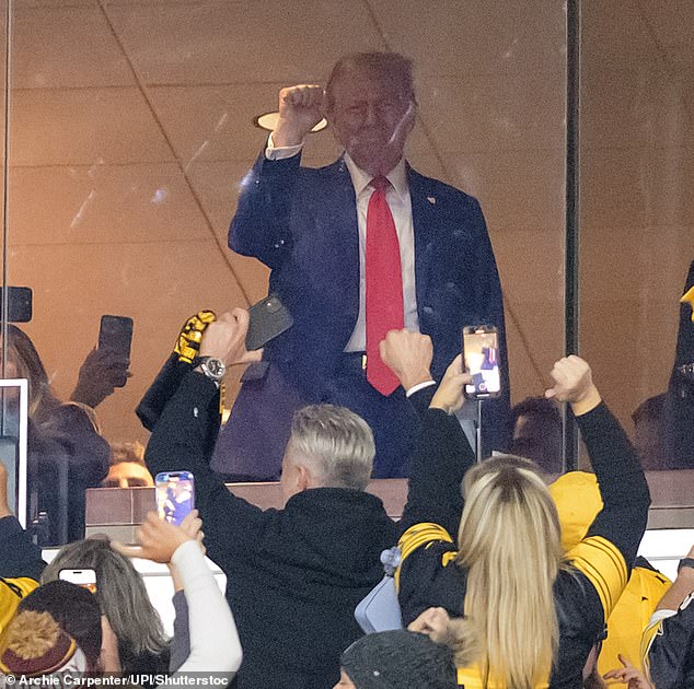 Trump waves back to Steelers fans cheering him on during a break in Sunday's game