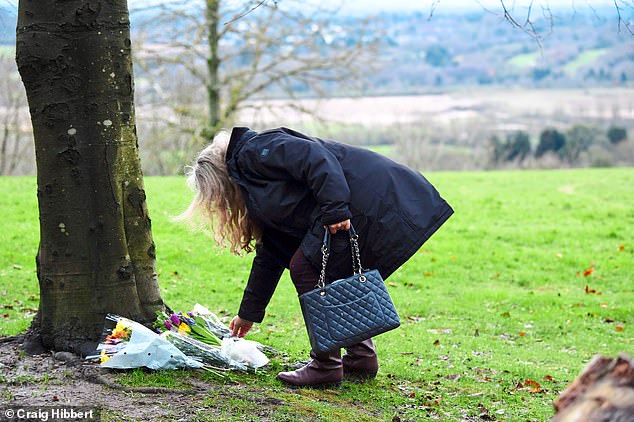 A woman lays flowers at the site of the fatal dog mauling