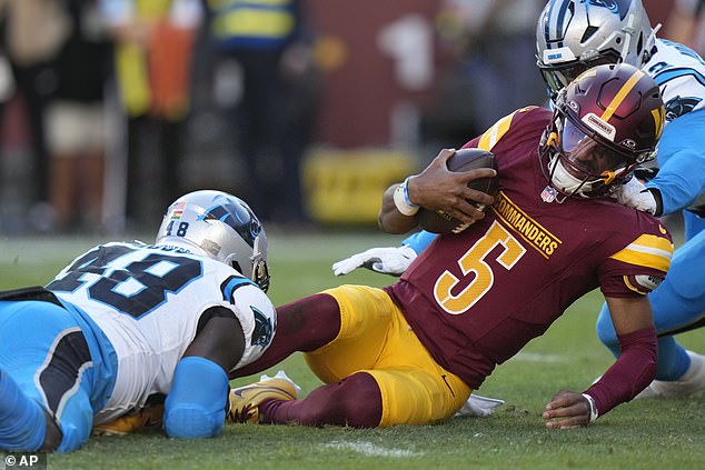 Commander QB Jayden Daniels (5) is tackled by Panthers linebacker Thomas Incomom