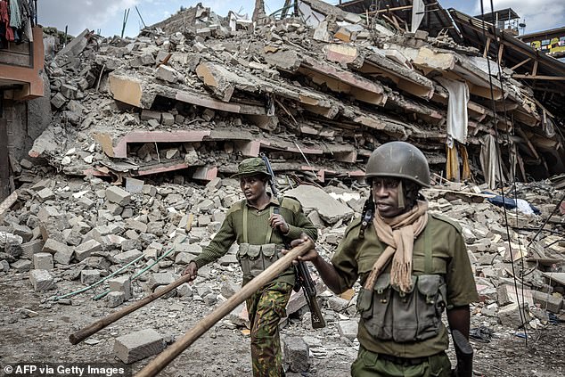 Police officers in Kenya give instructions to bystanders to evacuate the area next to the collapsed residential building