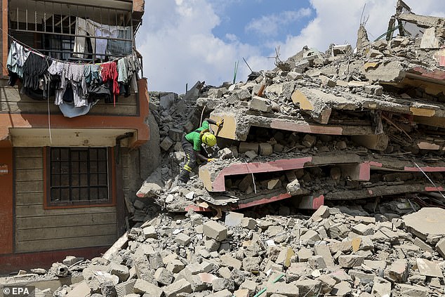 A Kenyan aid worker inspects the rubble during a search and rescue mission