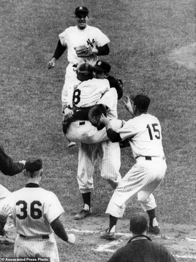 Yankees catcher Yogi Berra (8) jumps into the arms of pitcher Don Larsen after Larsen threw the first perfect game in World Series history, beating the Brooklyn Dodgers 2-0 in 1956