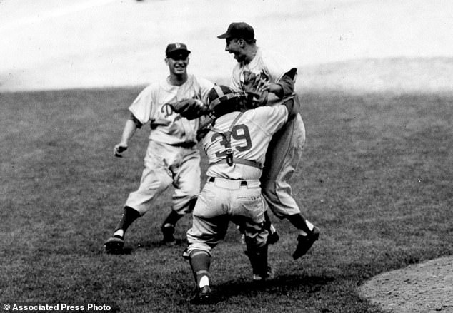 Brooklyn Dodgers pitcher Johnny Podres is lifted by catcher Roy Campanella (39) in 1955