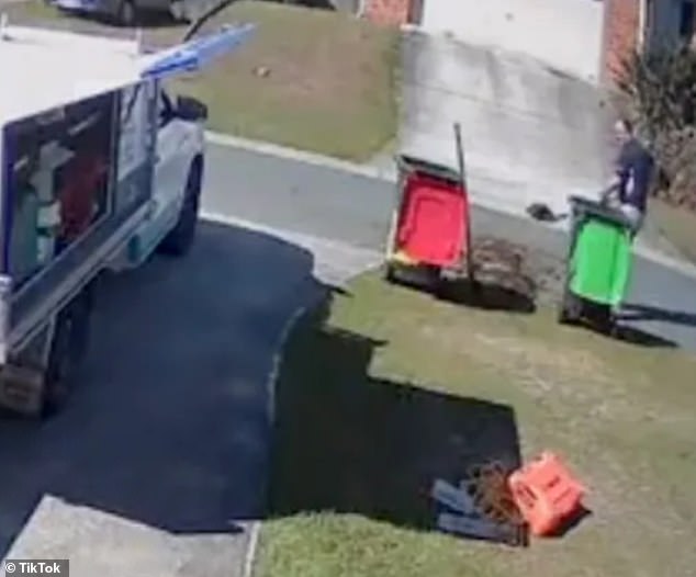 The truck drove away after two failed attempts to empty the bin and the man had to scoop the contents from the road