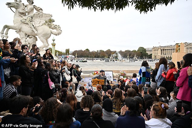 A singer performs on Sunday as Payne's fans gather to pay tribute at the Jardin des Tuileries in Paris