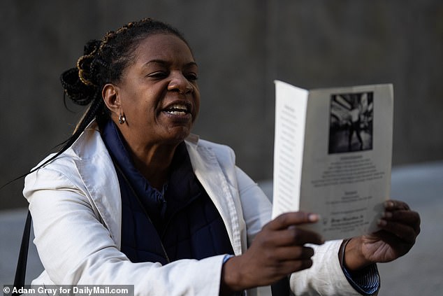 Pictured: A woman holds a funeral order for Jordan Neely before Daniel Penny arrives at Manhattan Criminal Court in New York City on October 21