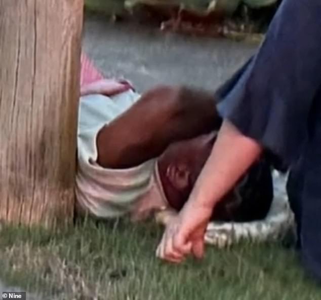 Mum is pictured lying on the ground in the aftermath of the collision in the Brisbane suburb of Bardon last Friday