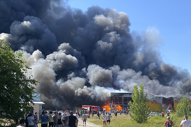 Spectators gather as flames engulf the mall shortly after it was hit by two Russian guided missiles