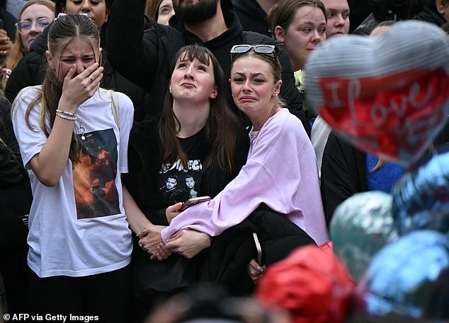 Mourning Londoners gather with balloons next to the Peter Pan statue in Kensington Garden