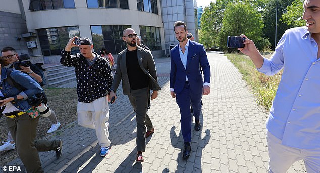 Former professional kickboxer and social media influencer Andrew Tate (CL) and his brother Tristan (CR), assisted by their bodyguards and surrounded by journalists, leave the building after a pre-trial hearing for lifting the seizure of assets of the Bucharest District Court, in Bucharest, Romania, September 23, 2024