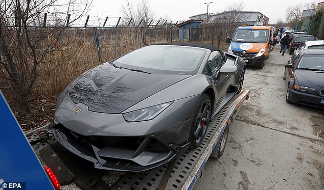 A Lamborghini sports car owned by Andrew Tate is taken by Romanian law enforcement officers in January 2023