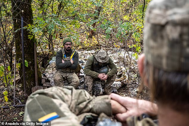 A group of Ukrainian soldiers rest after firing a howitzer at Russian positions in Donetsk Oblast, Ukraine on October 21, 2024