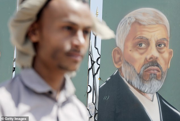 A Yemeni man looks at a work of art depicting Yahya Sinwar, the head of the Hamas Political Bureau