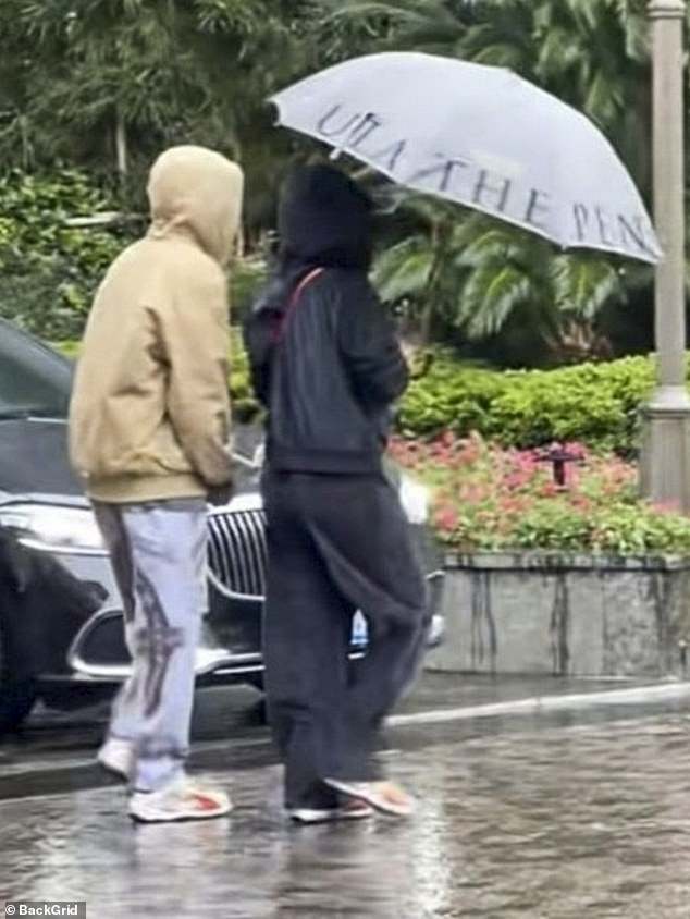 The couple walked hand in hand through the city while covering themselves with an umbrella